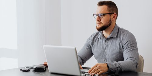 Άτομο που συμπληρώνει την ηλεκτρονική αίτηση του προγράμματος σε υπολογιστή.